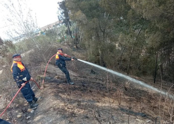 Protecció Civil d'Abrera remulla la zona afectada pel foc a la riera Magarola